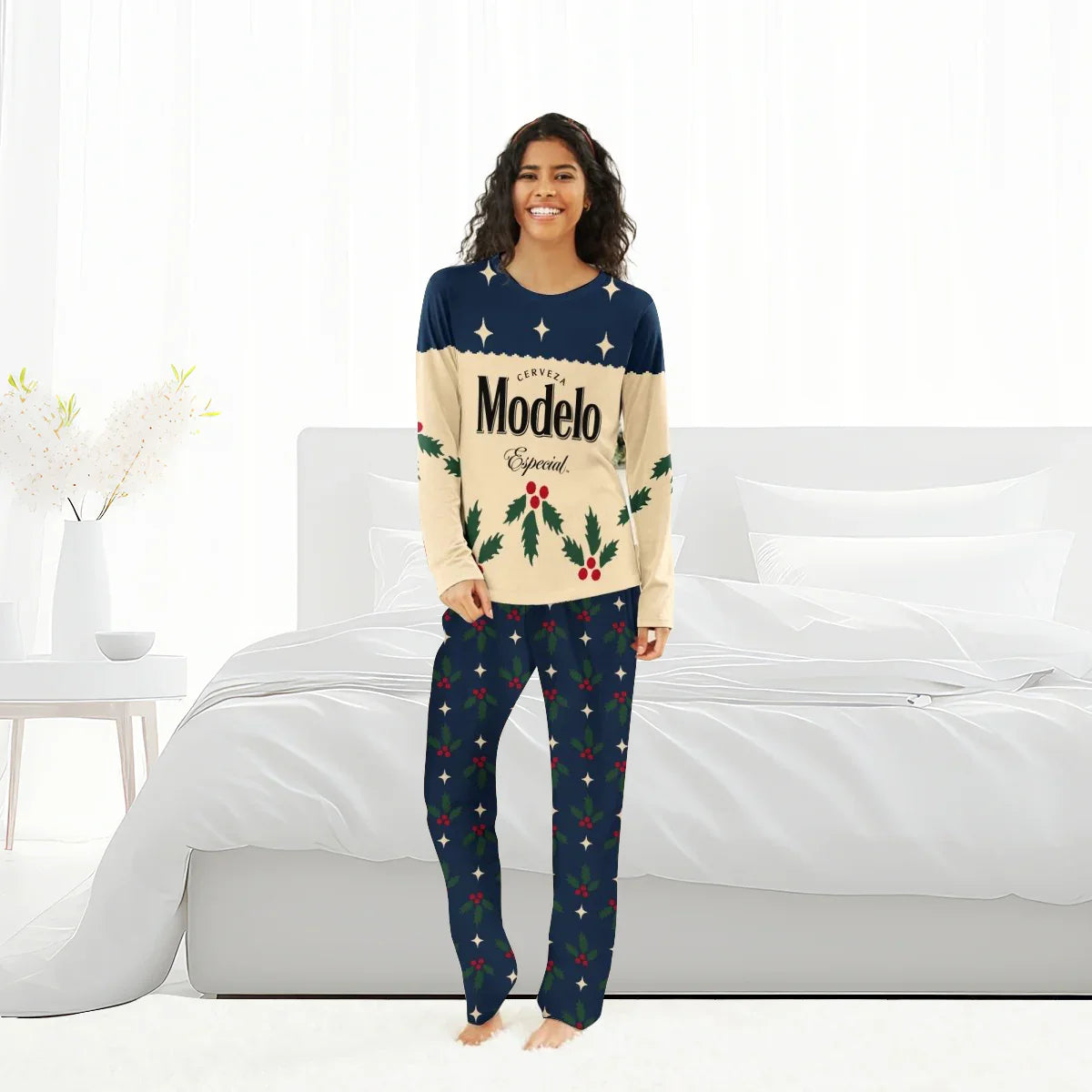 Smiling woman in Modelo Especial Christmas pajamas with holly and star patterns in bright bedroom