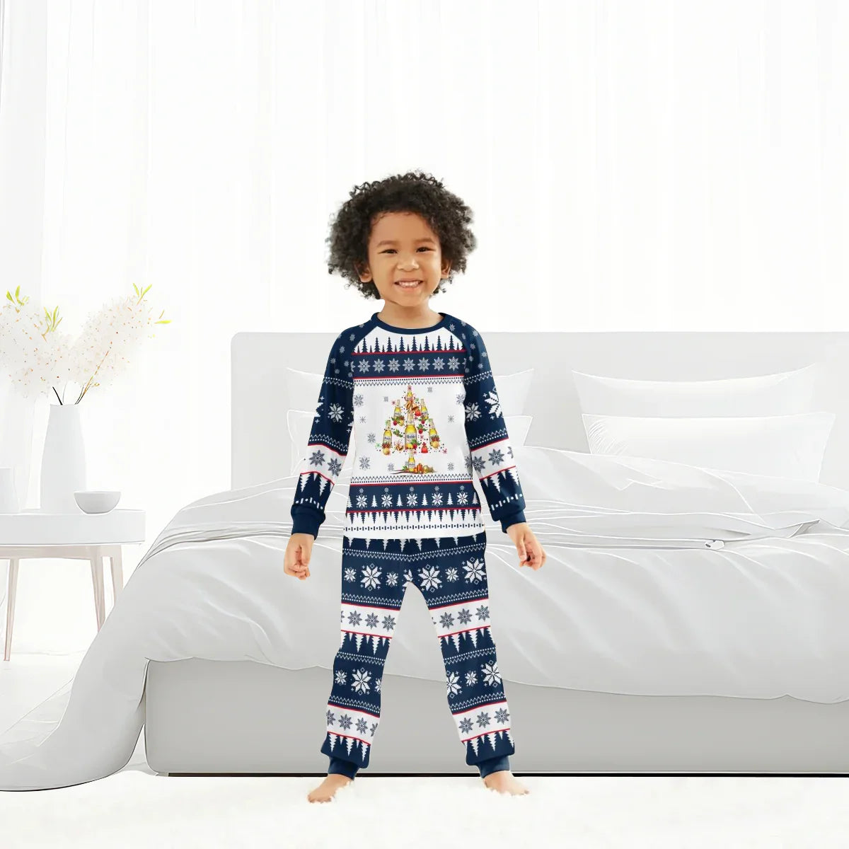 Smiling child in blue and white Christmas tree holiday pajamas standing barefoot in bright bedroom