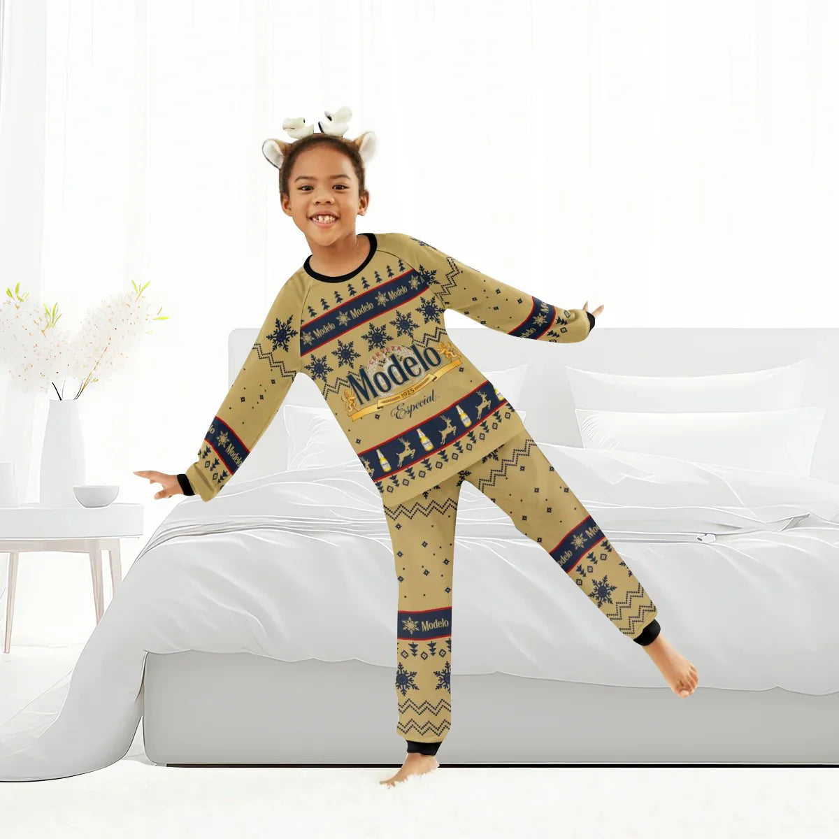 Child wearing Modelo Especial holiday pajamas standing on one leg in bright, white bedroom