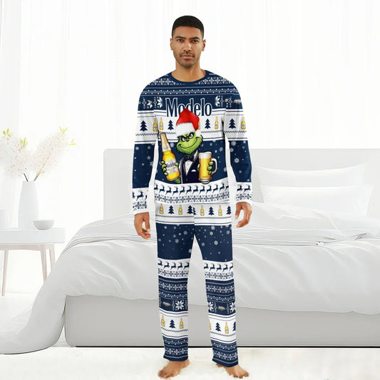 Man wearing navy blue Modelo Grinch Christmas pajamas with holiday patterns in a white bedroom