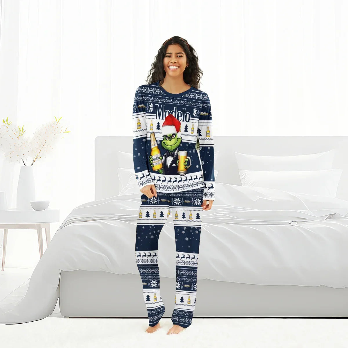 Smiling woman in Modelo Grinch Christmas family pajamas standing in a bright bedroom