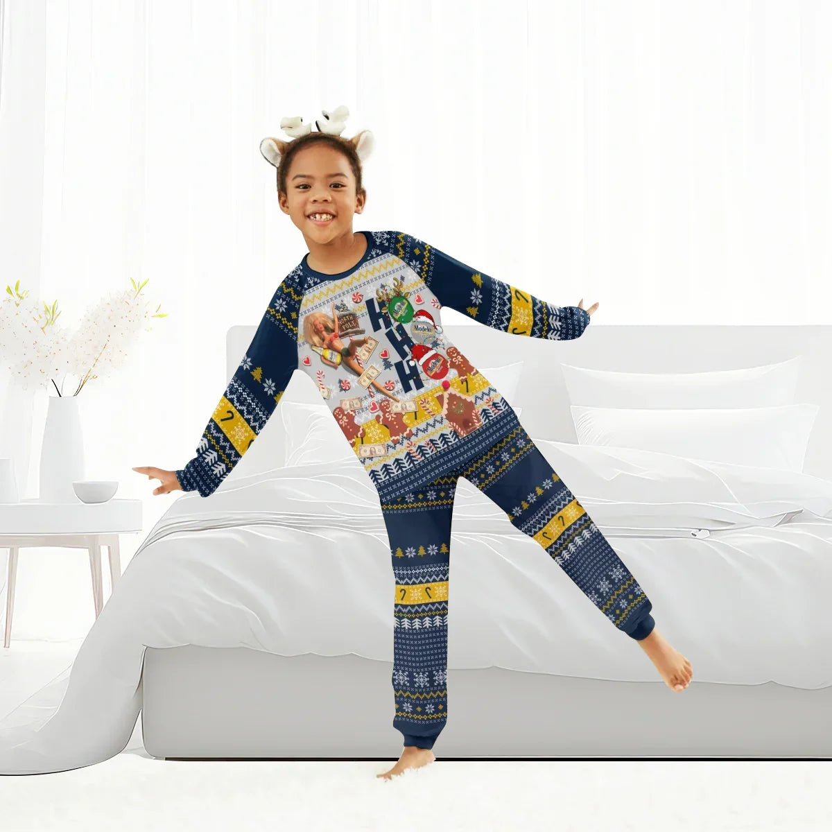 Smiling child wearing Christmas-themed blue and yellow holiday pajamas in bright white bedroom
