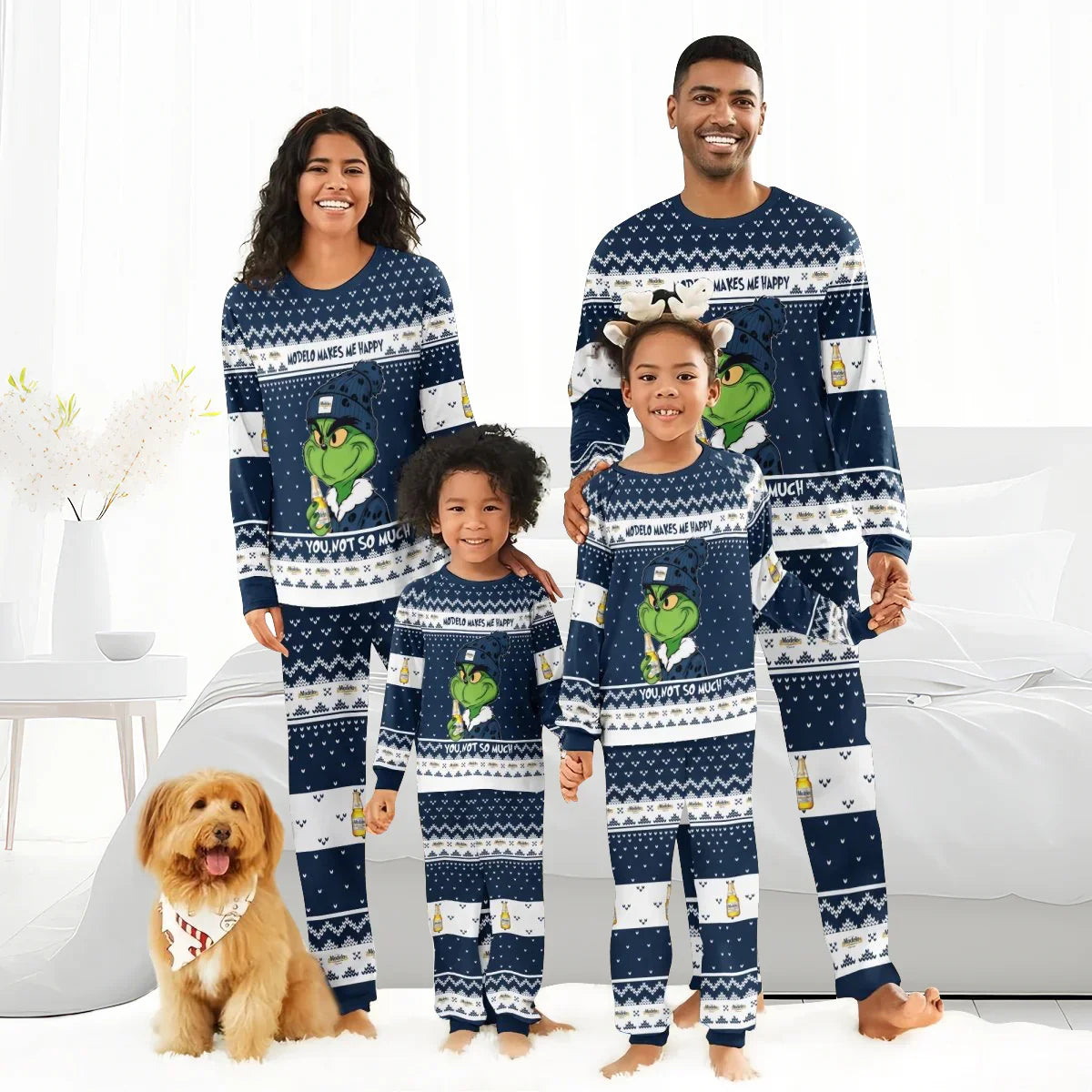 Happy family wearing matching navy Grinch-themed Modelo pajama sets in cozy bright bedroom with dog