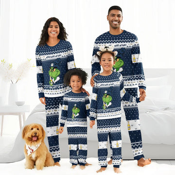 Happy family wearing matching navy Grinch-themed Modelo pajama sets in cozy bright bedroom with dog
