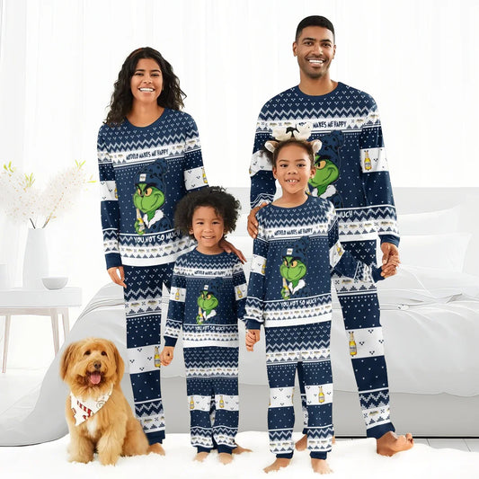 Happy family wearing matching navy Grinch-themed Modelo pajama sets in cozy bright bedroom with dog