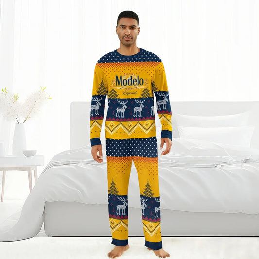 Man wearing yellow and navy Modelo reindeer family Christmas pajamas standing barefoot in bright bedroom