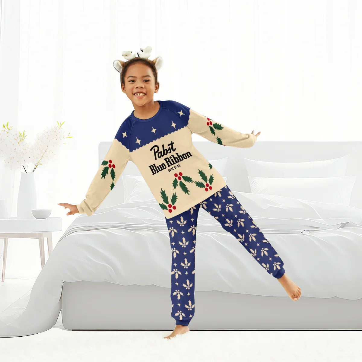 Child wearing Pabst Blue Ribbon Christmas cherry pajamas with festive holly design in bright bedroom