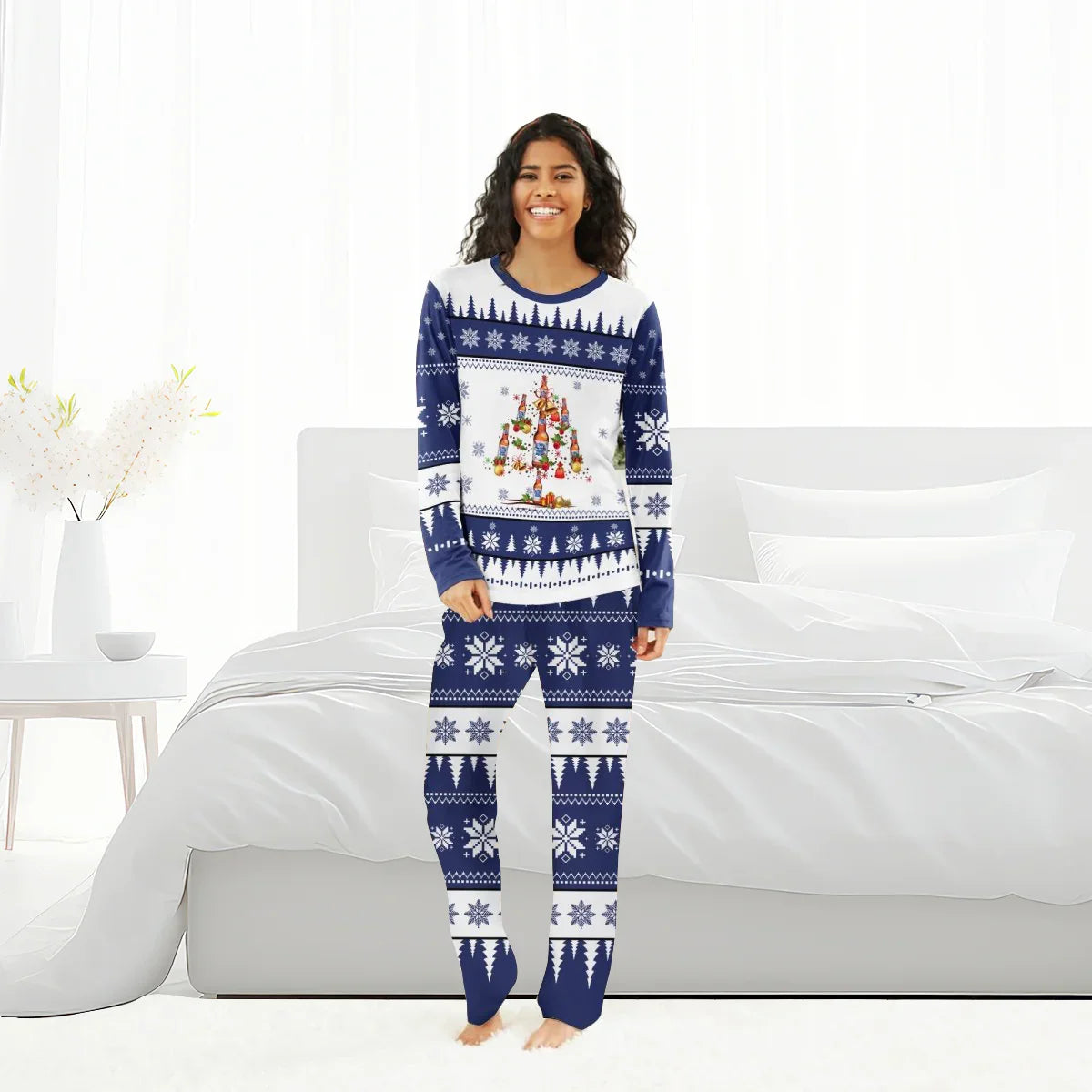 Woman in blue and white Christmas pajamas with snowflake and beer bottle tree design standing in bright bedroom