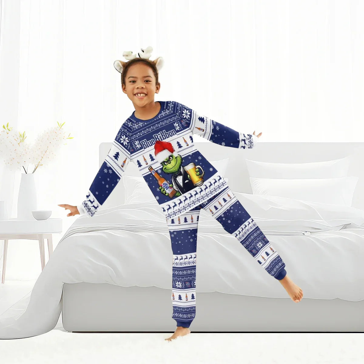 Child wearing blue Pabst Blue Ribbon holiday pajamas with Grinch design in bright white bedroom