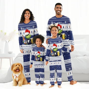 Smiling family of four wearing matching blue Pabst Blue Ribbon holiday pajamas with the Grinch and festive patterns, with a dog wearing a holiday bandana