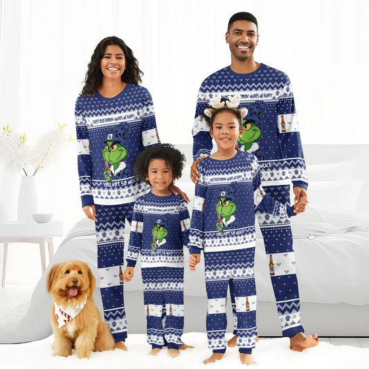Smiling family in matching blue Grinch and Pabst Blue Ribbon holiday pajamas with dog in festive bandana