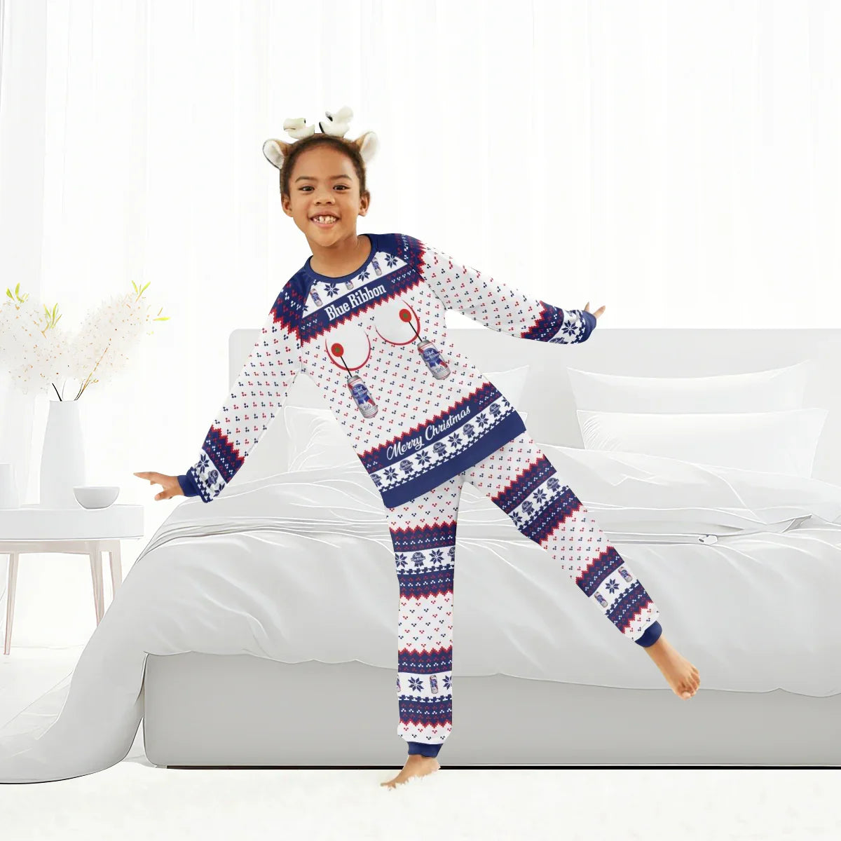 Child wearing Pabst Blue Ribbon Christmas family pajamas with reindeer antler headband in bright bedroom