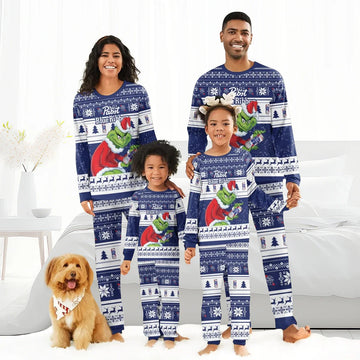 Smiling family wearing matching blue Pabst Blue Ribbon Grinch Christmas pajamas with snowflakes and reindeer, dog with bandana
