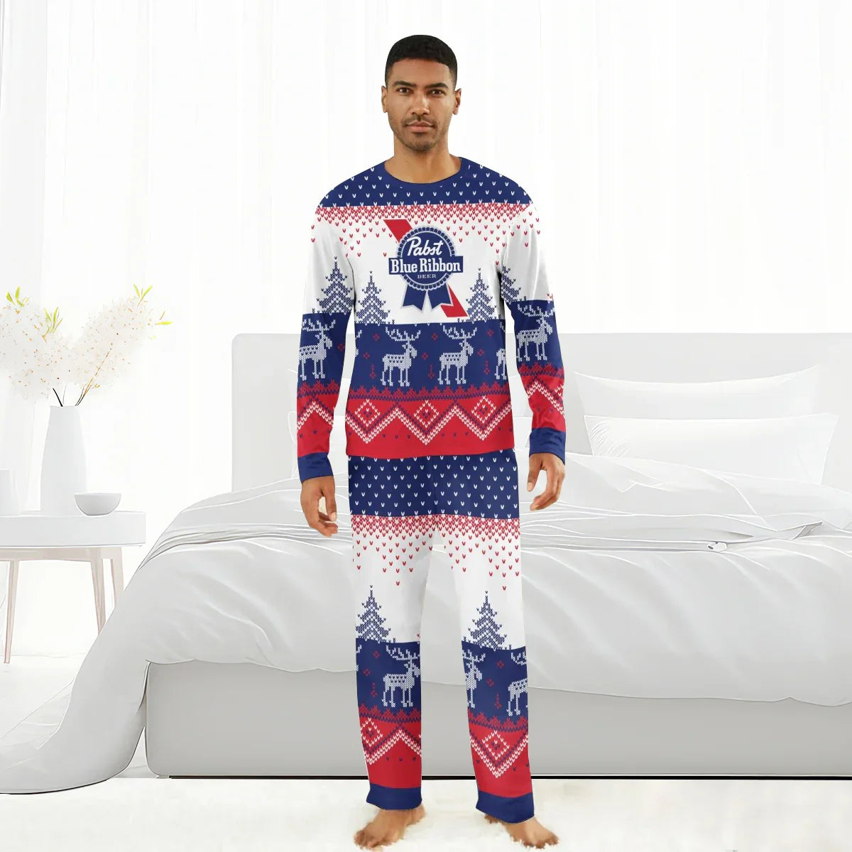 Man wearing red, white, and blue Pabst Blue Ribbon winter reindeer family pajamas in a bright bedroom