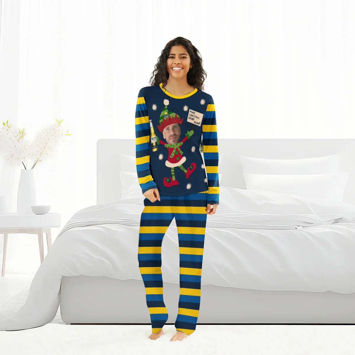 Smiling woman in blue and yellow striped Christmas pajamas with personalized elf design holding Corona beer bottle