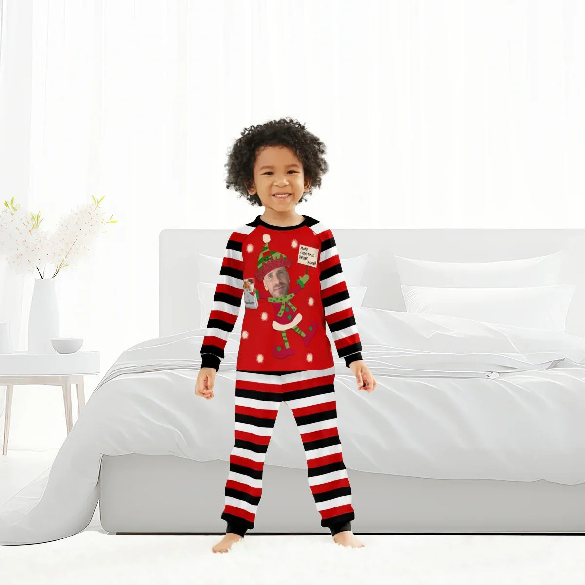 Smiling child in red and black striped Christmas pajamas with elf and Marlboro design in modern bedroom