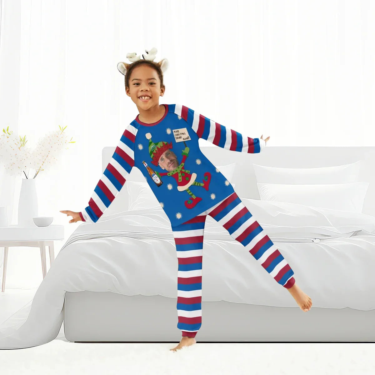 Smiling child wearing personalized Christmas pajamas with red, white, blue stripes and festive elf design