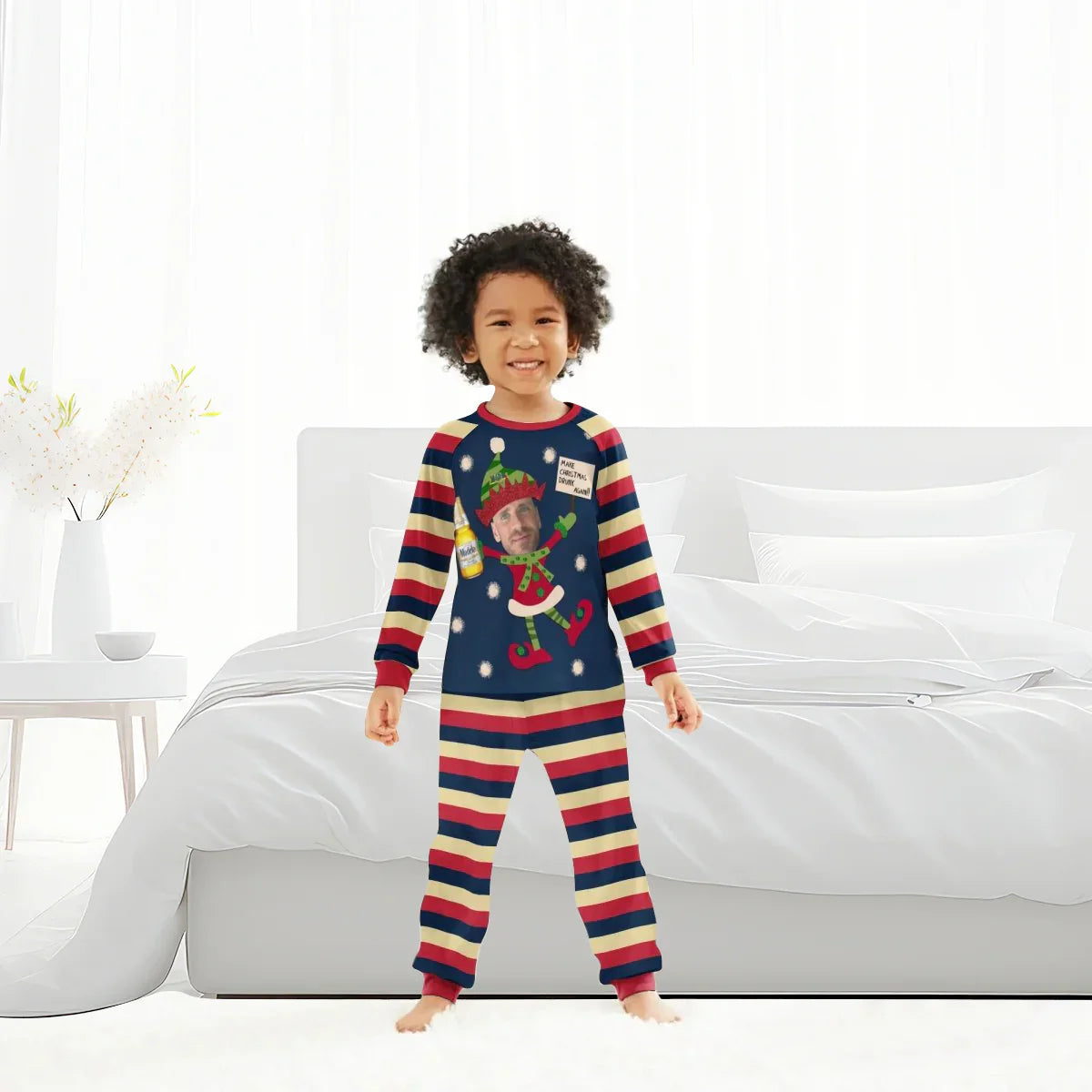 Smiling child in striped Christmas pajamas with elf and bottle design in bright bedroom
