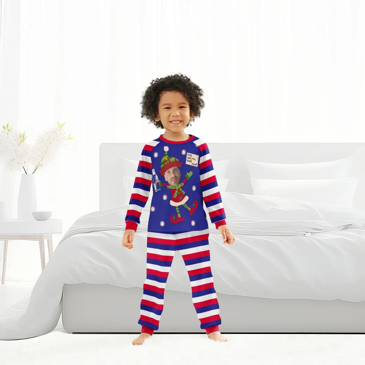 Happy child in red, white, and blue striped Christmas pajamas with elf and personalized photo design