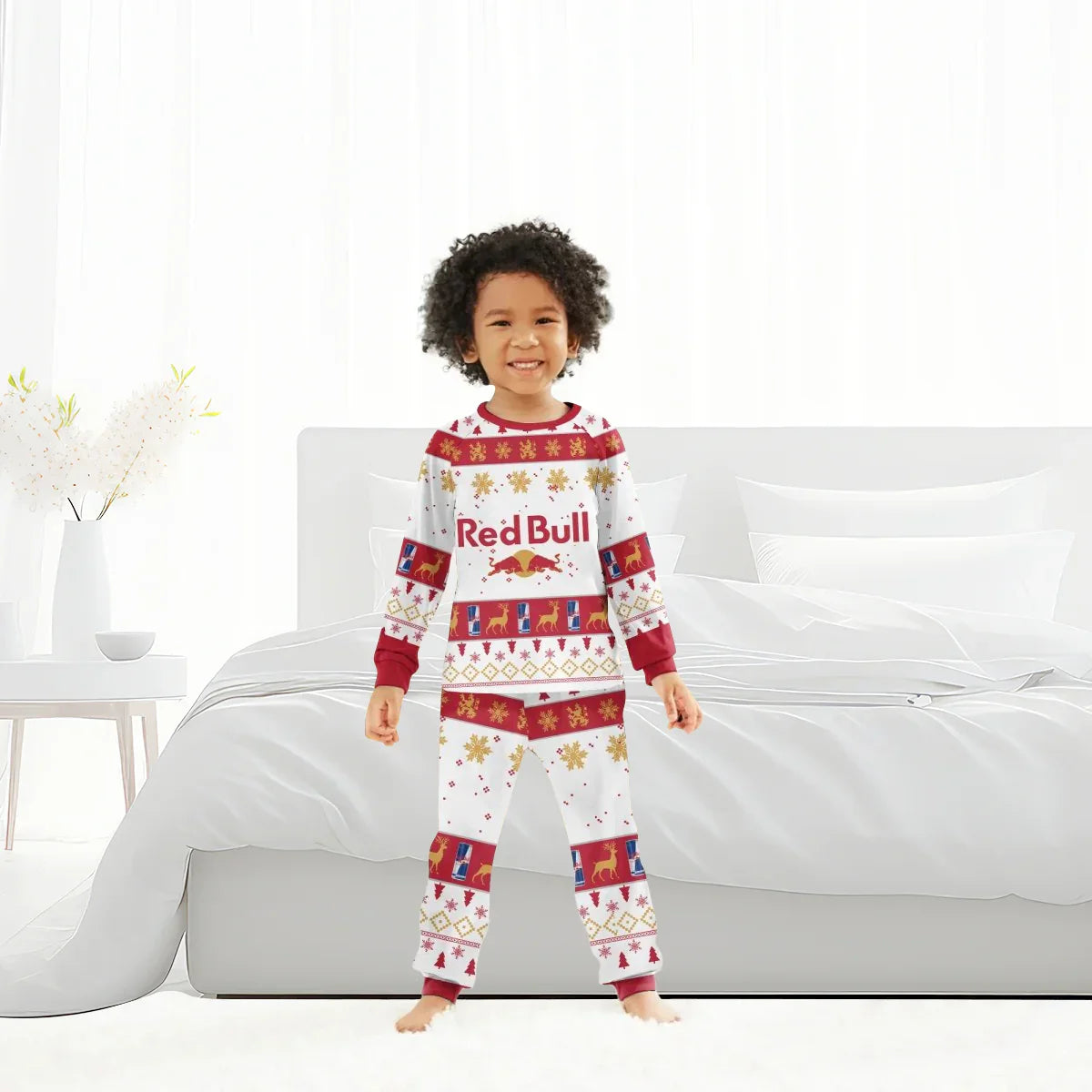 Smiling child in Red Bull holiday pajamas standing barefoot in bright bedroom with white bed and decor