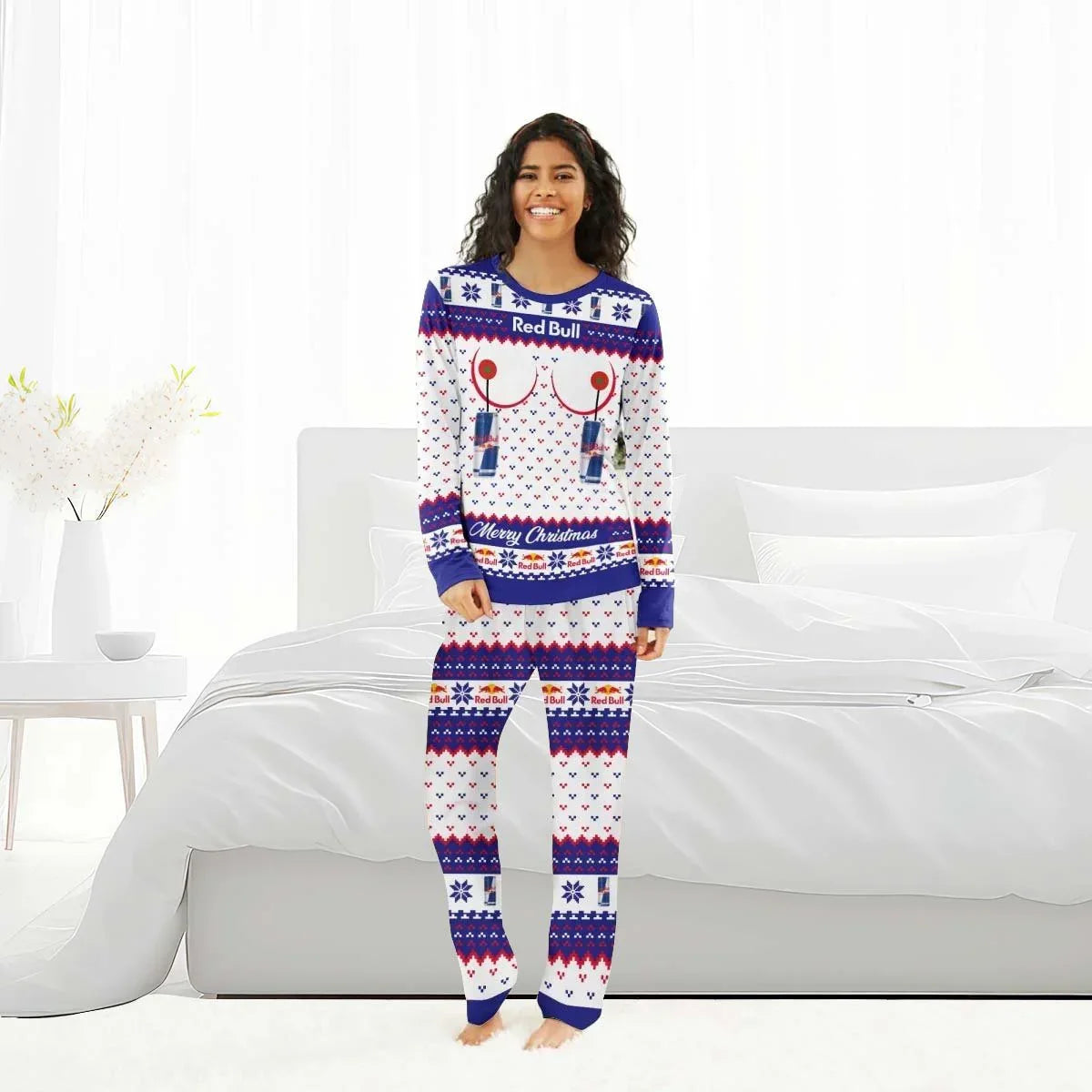 Smiling woman in Red Bull themed Christmas pajamas standing barefoot in bright white bedroom