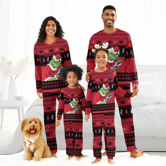 Smiling family in matching Red Bull Grinch Christmas pajamas with holiday patterns, dog with candy cane bandana