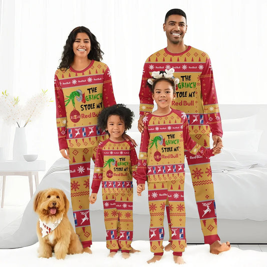 Family wearing matching red and gold Grinch-themed Red Bull Christmas pajamas with a dog in a holiday bandana