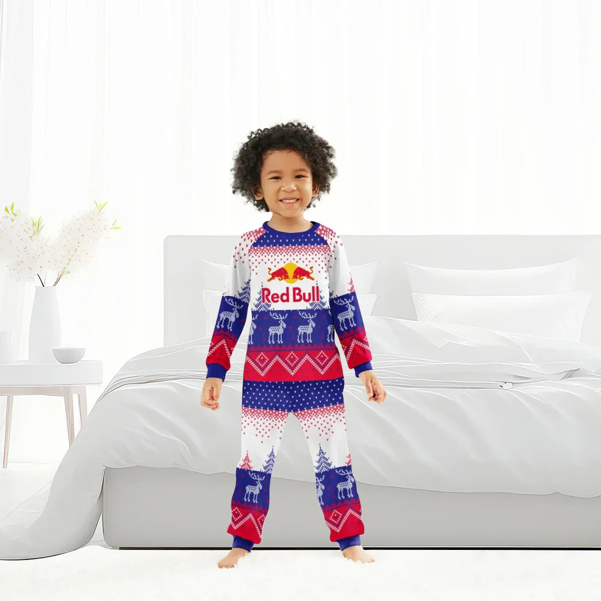 Child smiling in bedroom wearing Red Bull winter pajamas with reindeer and holiday patterns