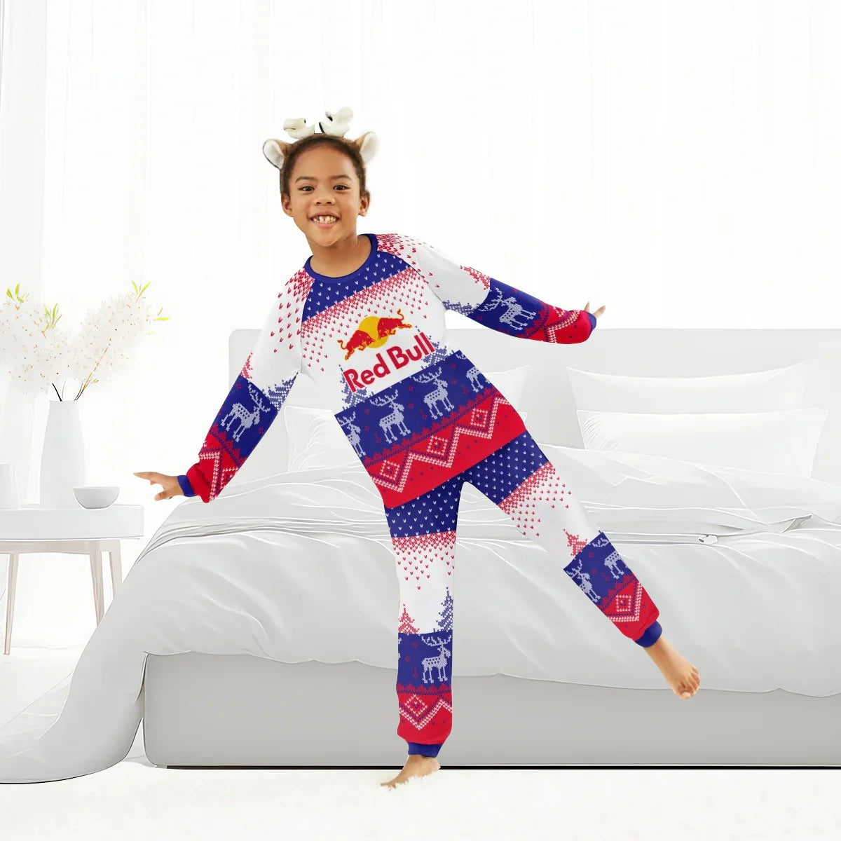Child in festive Red Bull winter reindeer family pajama set with antler headband in bright bedroom