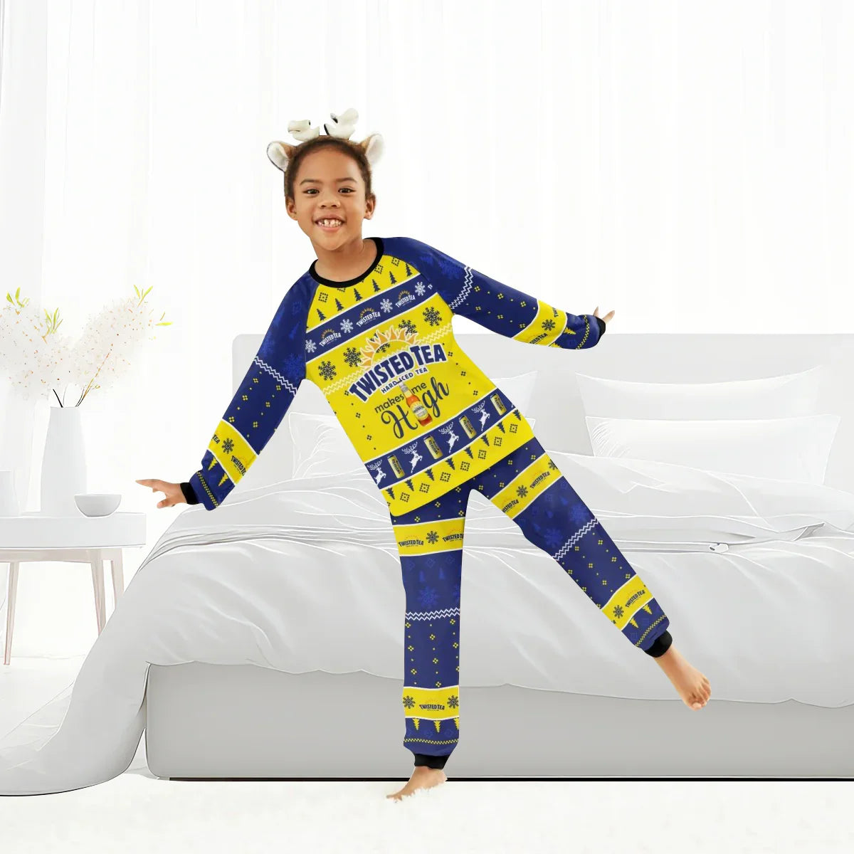 Child wearing blue and yellow Twisted Tea Christmas family pajamas in a bright bedroom