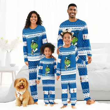 Smiling family wearing matching blue Grinch and Michelob Ultra holiday pajamas in bright living room with dog